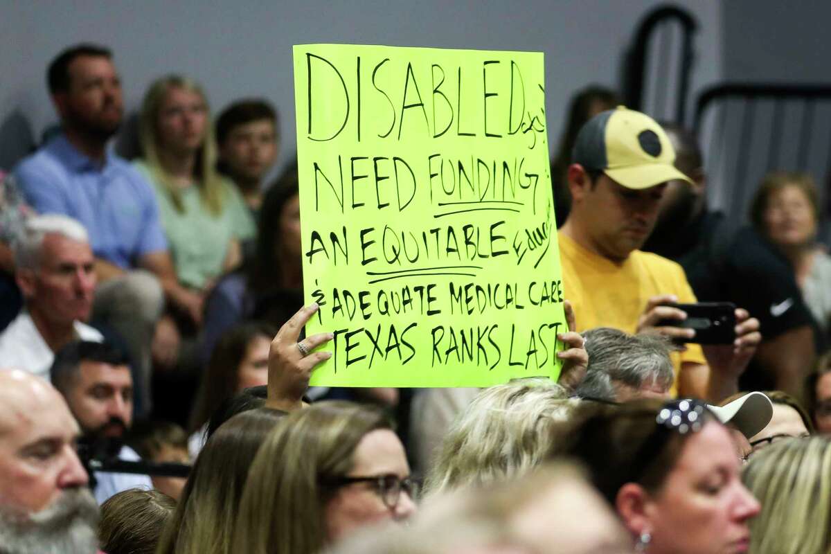 A person holds up a sign as Gov. Greg Abbott addresses “school choice” and his support for legislation that would give parents state money to cover tuition at schools outside of the state's public school system at Parent Empowerment Night at Covenant Christian School, Tuesday, Feb. 28, 2023, in Conroe.