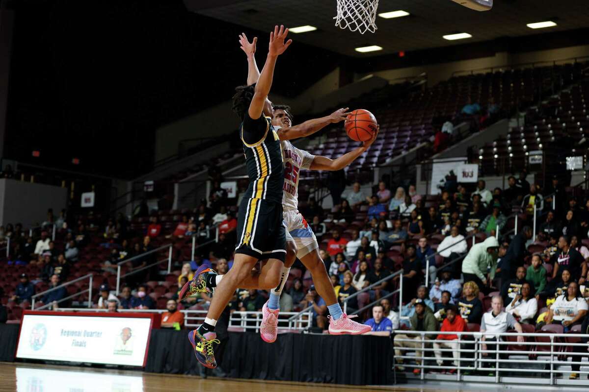 Madison Marlins Mason Allen (25) goes up for a shot defended by Fort Bend Marshall Buffalos Jaylen Reed’s (11) in the first half during the Region III-5A quarterfinal playoff game between the Fort Bend Marshall Buffalos and the Madison Marlins at the Campbell Center on Tuesday, Feb. 28, 2023 in Houston, Texas.