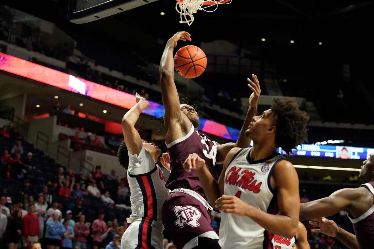 Texas A&M forward Julius Marble (34) reacts as he is bumped after making a layup by Mississippi defenders during the first half of an NCAA college basketball game in Oxford, Miss., Tuesday, Feb. 28, 2023. (AP Photo/Rogelio V. Solis)