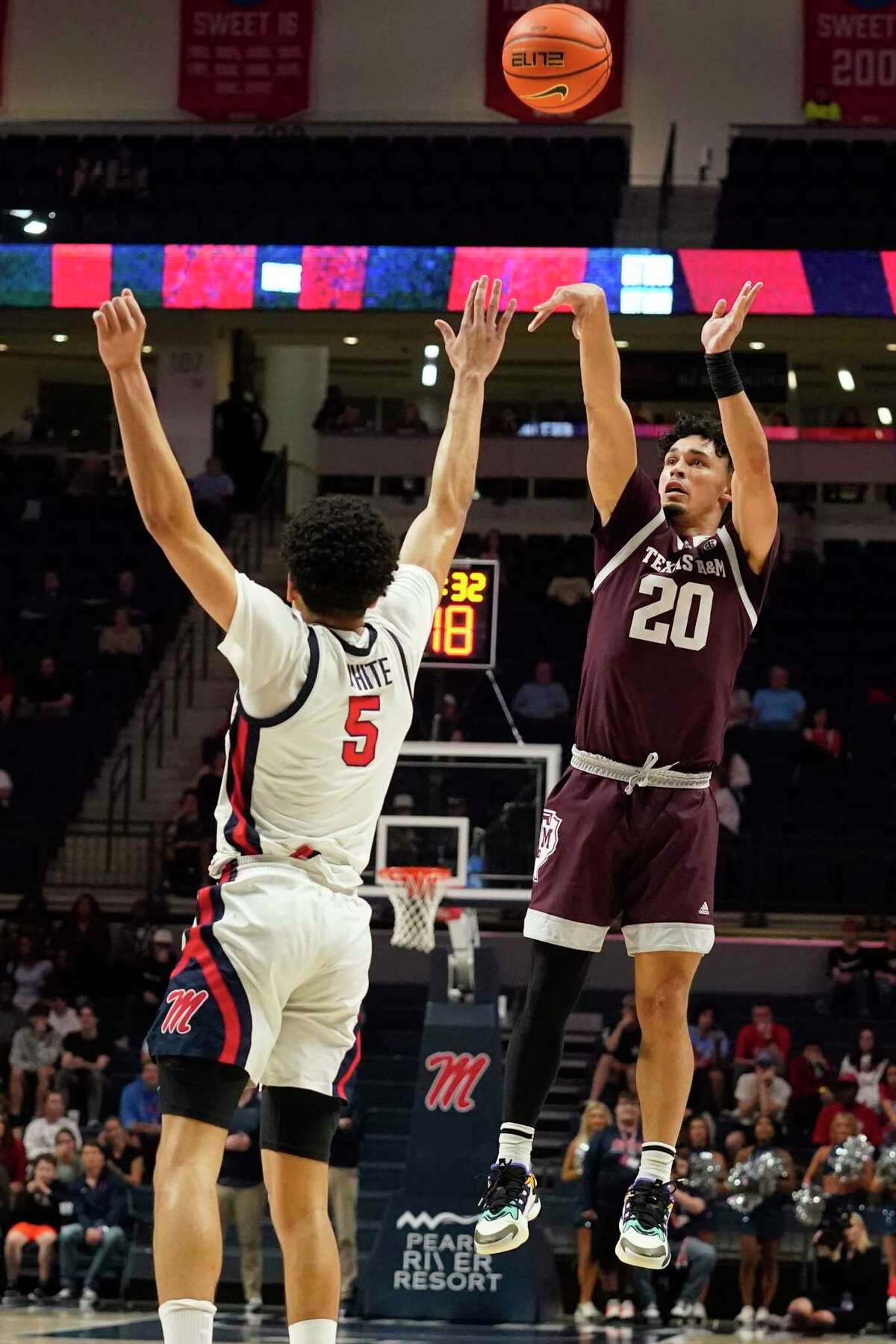 Texas A&M guard Andre Gordon (20) attempts a shot over the defense of Mississippi guard James White (5) during the first half of an NCAA college basketball game in Oxford, Miss., Tuesday, Feb. 28, 2023. (AP Photo/Rogelio V. Solis)