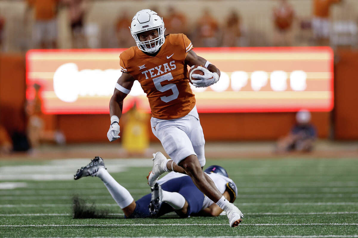 Bijan Robinson #5 of the Texas Longhorns runs past a West Virginia Mountaineers defender in the second half at Darrell K Royal-Texas Memorial Stadium on October 01, 2022 in Austin, Texas.