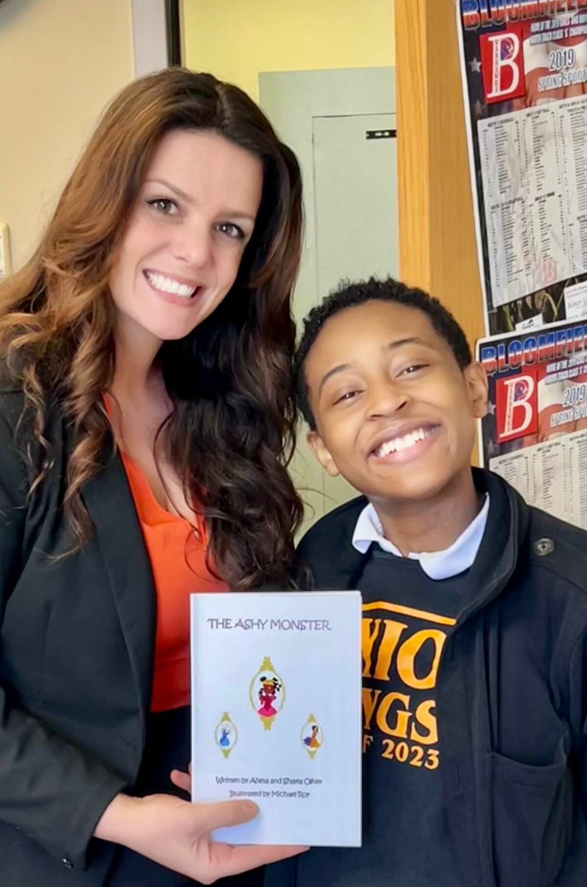 Shayla Oliver, 17, right, wrote her first children's book at age 10. She is pictured here with one of her elementary school teachers.