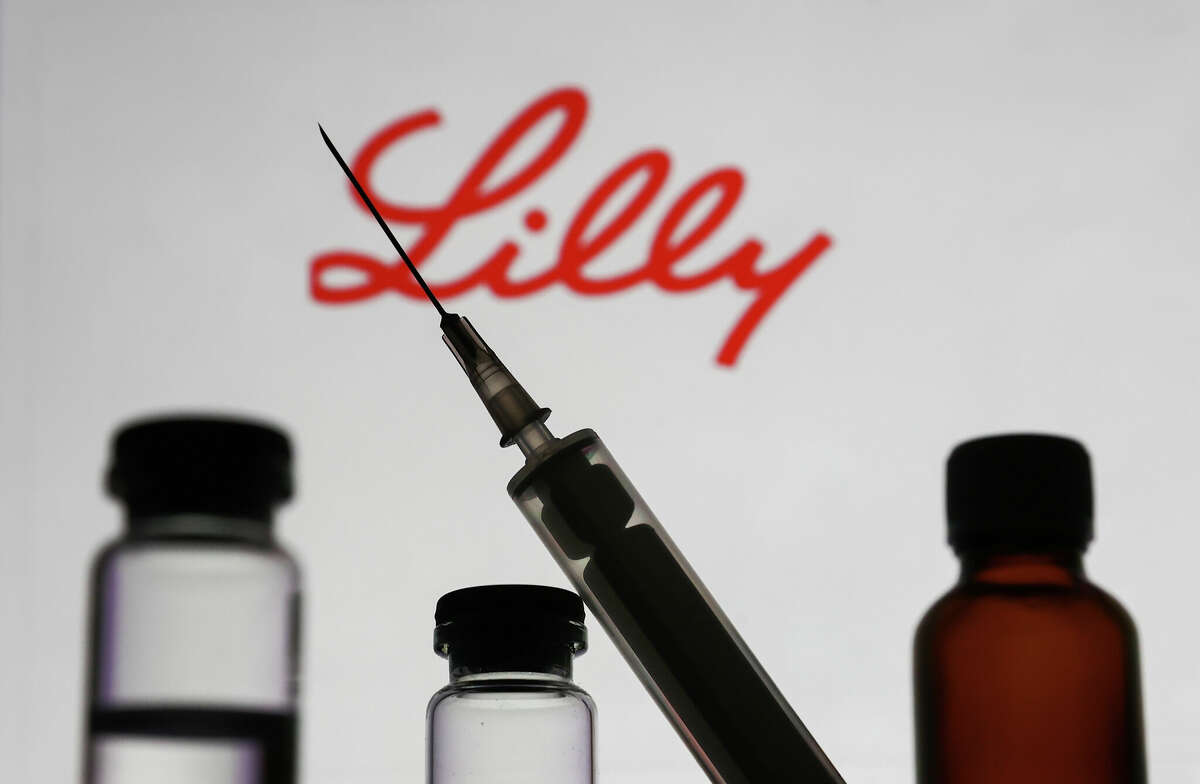 Eli Lilly and Company announced Wednesday they are cutting insulin costs by 70%, capping prices at $35. IMAGE: Medical bottles and syringe are seen with Eli Lilly and Company logo displayed on a screen in the background in this illustration photo taken in Krakow, Poland on November 10, 2022. (Photo by Jakub Porzycki/NurPhoto via Getty Images)