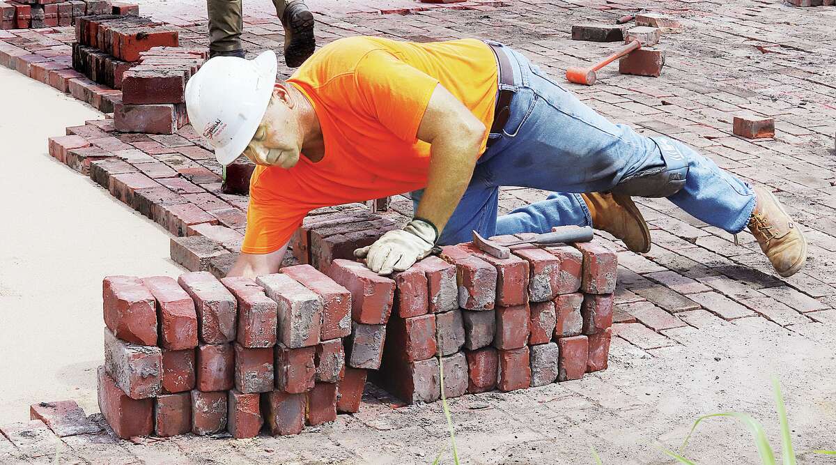 Workers replace bricks on 5th Street between Piasa and Belle as part of the sewer separation project in Alton last year in this file photo. Several brick streets and alleys in Alton are protected by ordinance, with a hearing planned Tuesday on expanding that list.