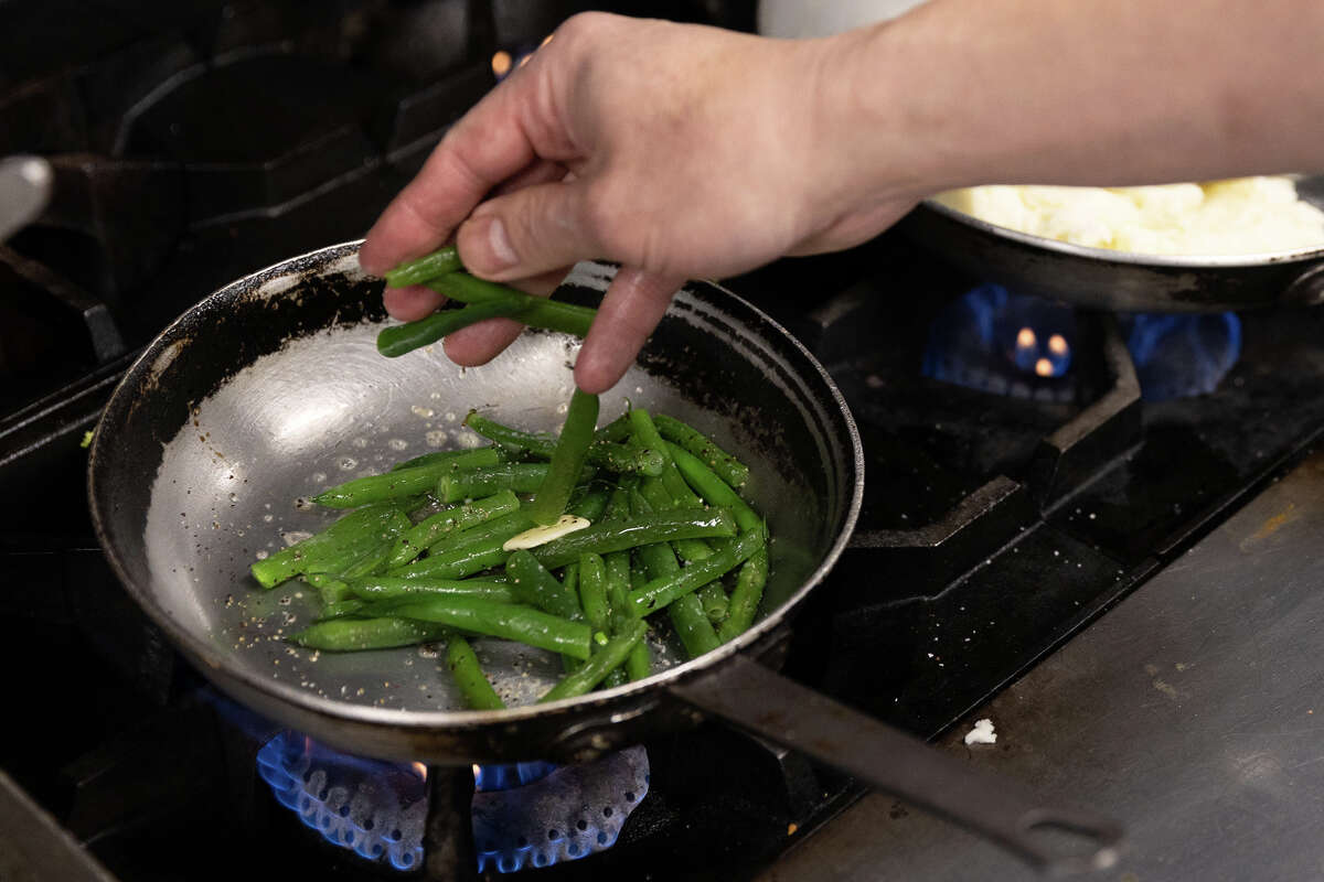 Chef Chris Hui cooks garlic green beans at the Gold Club on February 28, 2023 in San Francisco. 