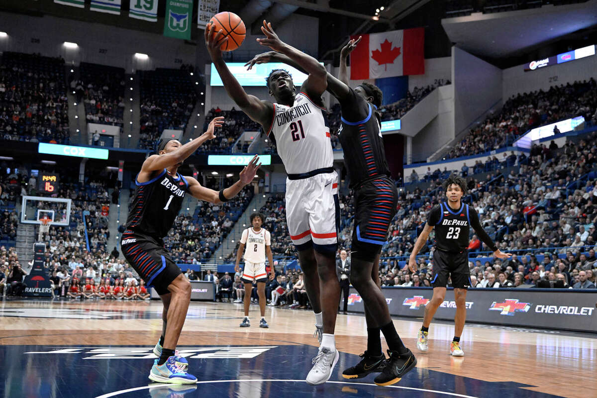 UConn's Adama Sanogo is fouled by DePaul's Yor Anei, right, as DePaul's Javan Johnson, left, defends, in the first half of an NCAA college basketball game, Wednesday, March 1, 2023, in Hartford, Conn. (AP Photo/Jessica Hill)