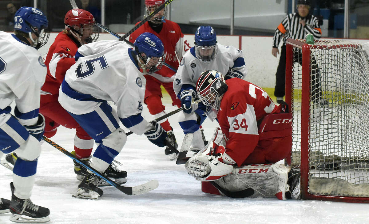 Greenwich goalie Nicholas Sinisi blocks a shot by Darien's Chris Davis (5) during the FCIAC boys ice hockey semifinals at the Darien Ice House on Wednesday, March 1, 2023.