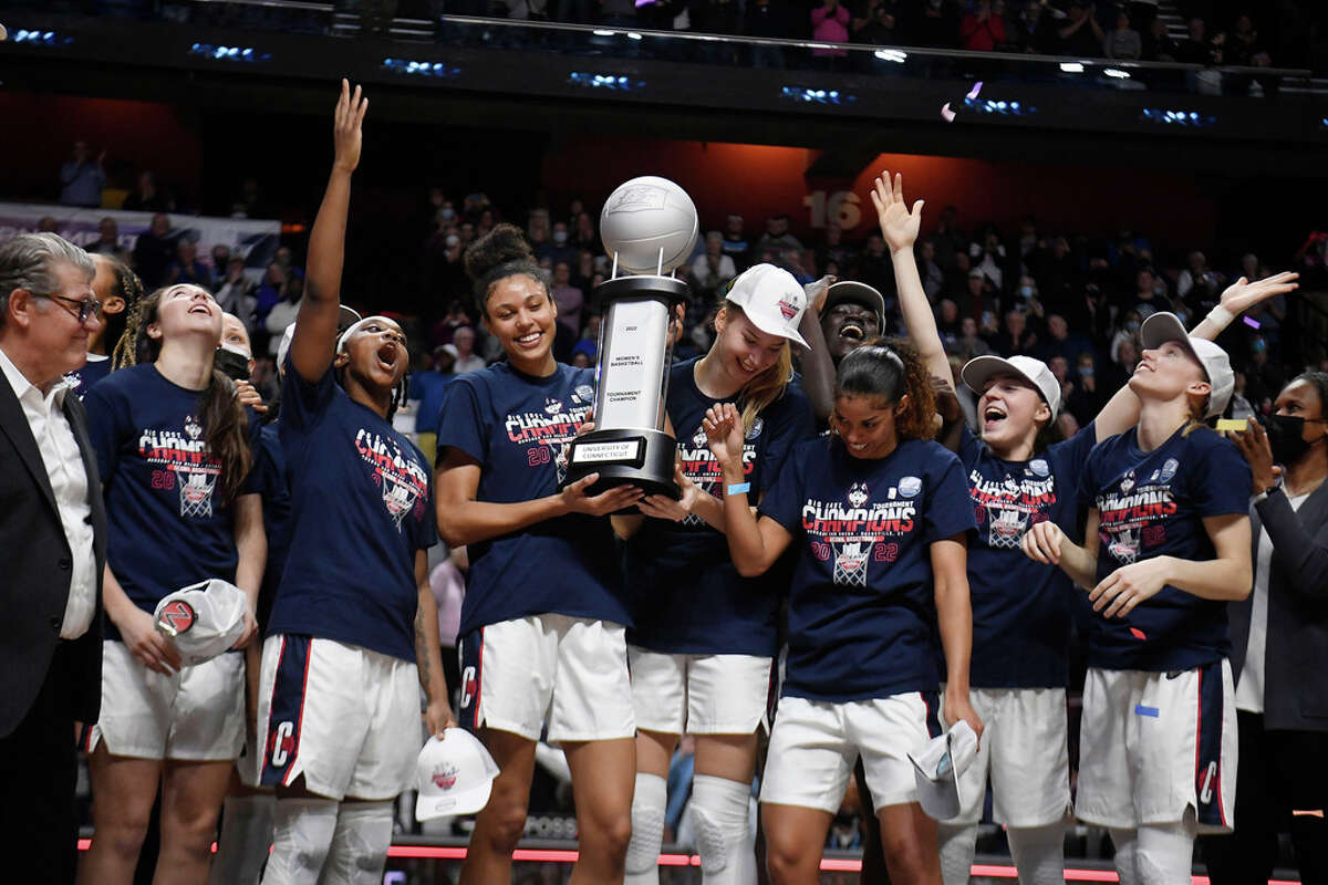 Connecticut players celebrate with the championship trophy after defeating Villanova in an NCAA college basketball game in the Big East tournament finals at Mohegan Sun Arena, Monday, March 7, 2022, in Uncasville, Conn. (AP Photo/Jessica Hill)