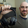 Dan Glass holds a pair of stereo headphones he is developing for people with unilateral deafness or hearing loss, in Trumbull, Conn. March 2, 2023.