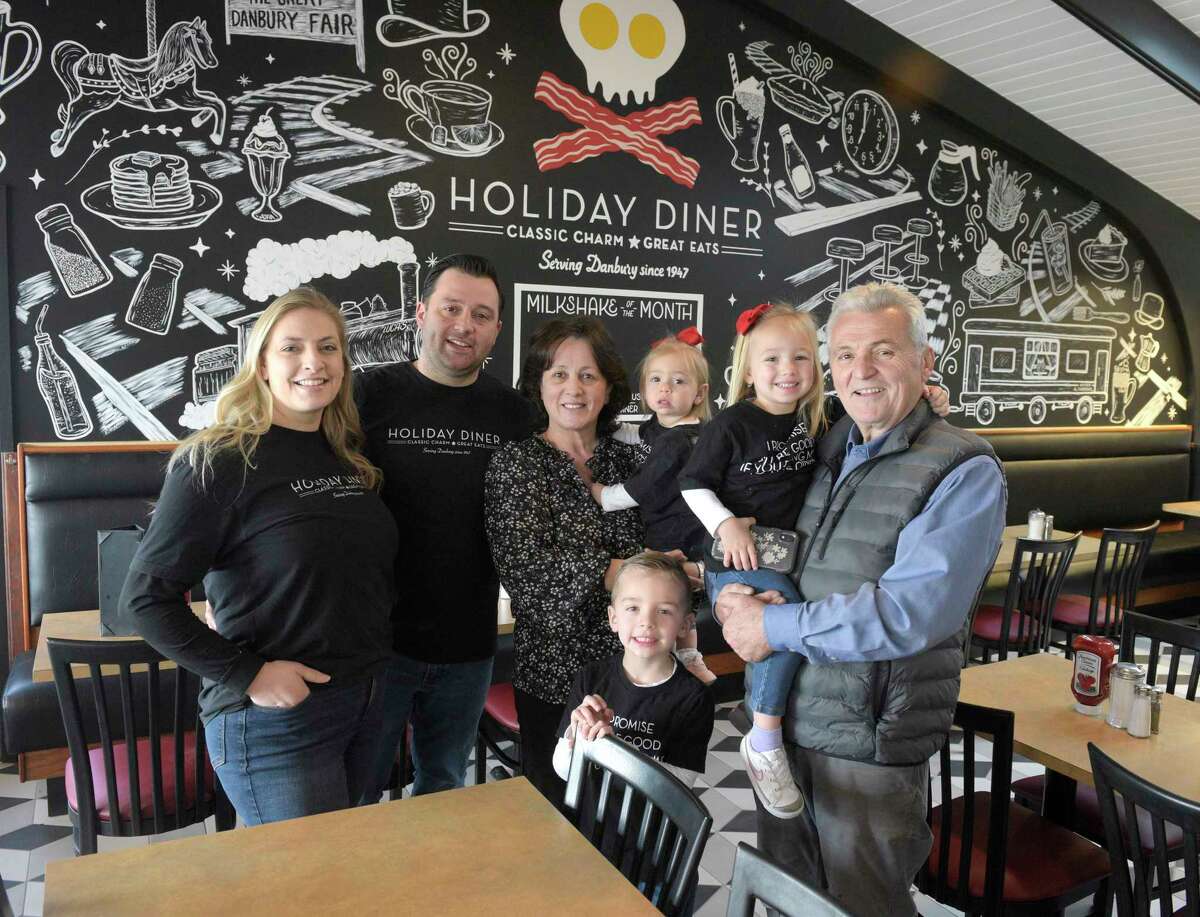 Diner owners George and Carla Psarofagis, left, with their family, Lucas, age 4; mother Maria Psarofagis; Sofia, age 1; Gianna, age 3; and father Bill Psarofagis. The Holiday Diner, which has been closed since Jan. 1 when renovations to the entire kitchen and part of the dining room started, is reopening on Monday, March 6. The family poses in the diner on Thursday, March 2, 2023, Danbury, Conn.