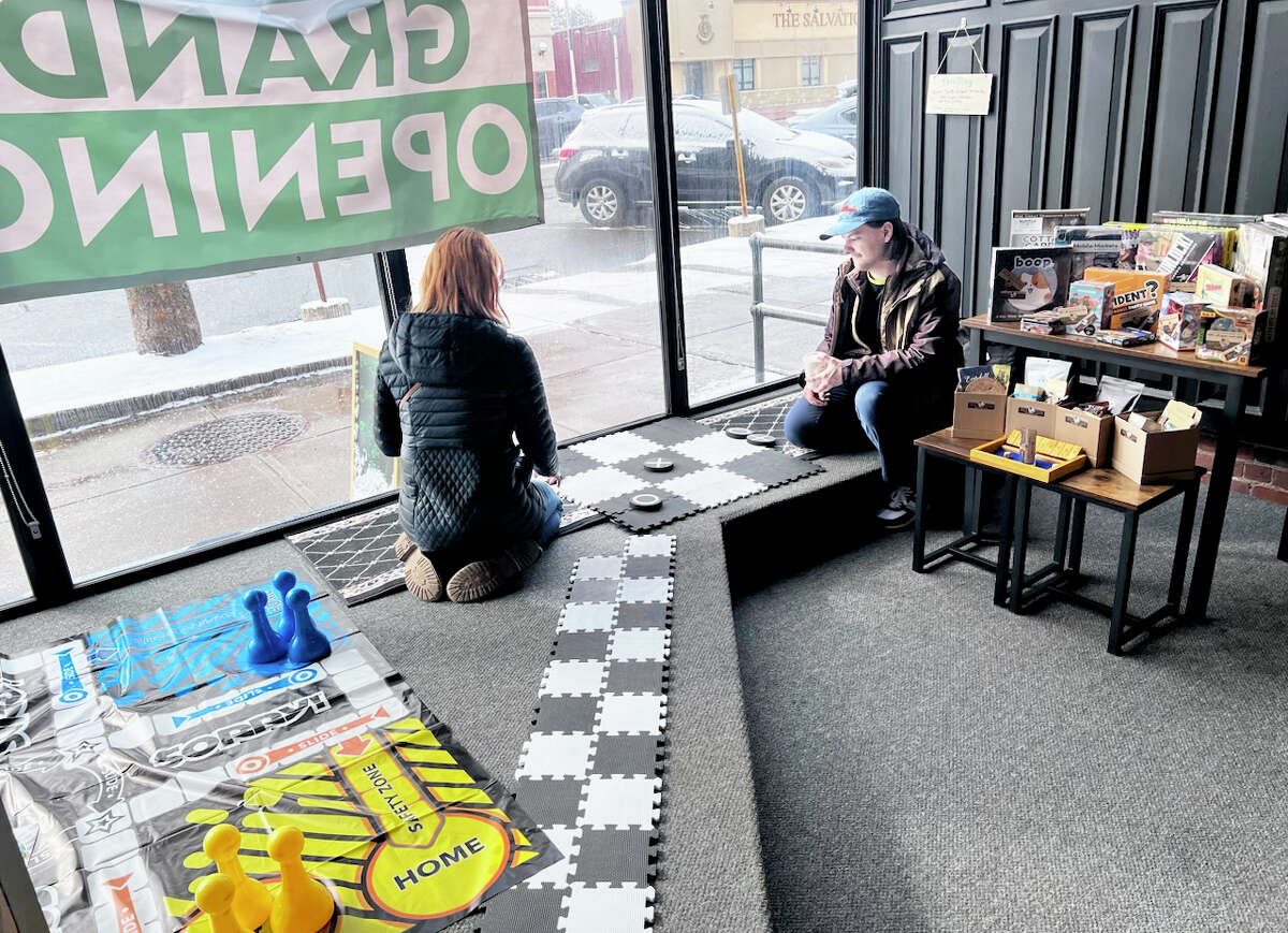 Back Again Board Game Cafe recently opened at 484 Main St. in Middletown. They have a large library of some 850 games to choose from, as well as a coffee shop. Here,  Chris Barone serves a customer order.Cafe owners Jennifer and Chris Barone are shown front of some of the 850 games available, and customers play checkers in the front window area. Sky Aceto, a customer from Middletown, holding a favorite game called Mansions of Madness.