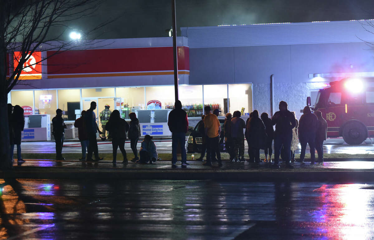 A crowd gathers in the Twisted Biscuit parking lot as firefighters  work to put out a fire inside the McDonald's/Circle K building on Thursday night in Edwardsville.