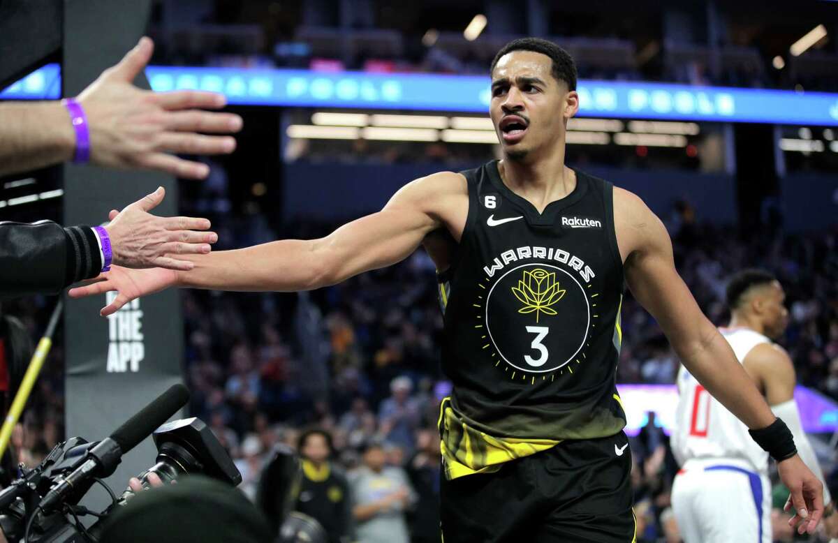 Jordan Poole (3) high fives fans after getting the foul call on a made basket in the second half as the Golden State Warriors played the Los Angeles Clippers at Chase Center in San Francisco, Calif., on Thursday, March 02, 2023.