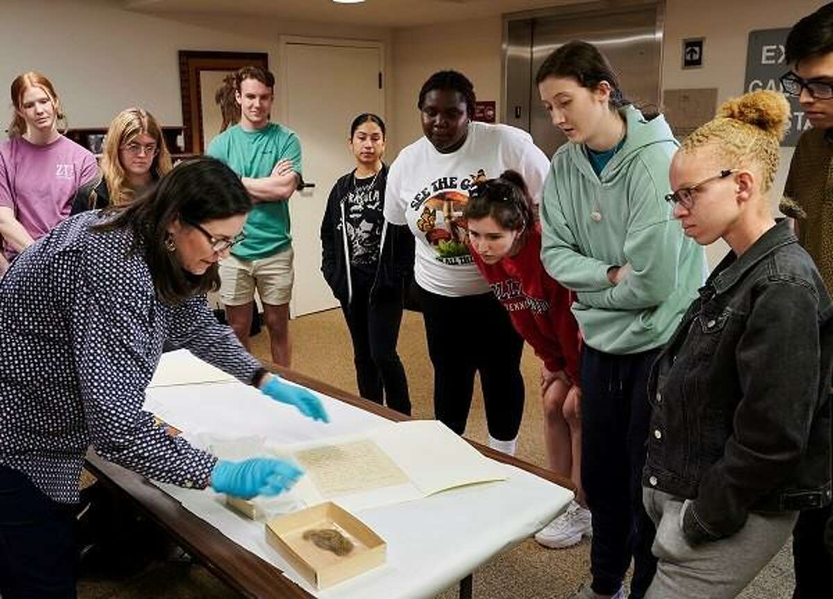 Rebecca Lewis shows Sam Houston State University students artifacts from the museum vault on campus.