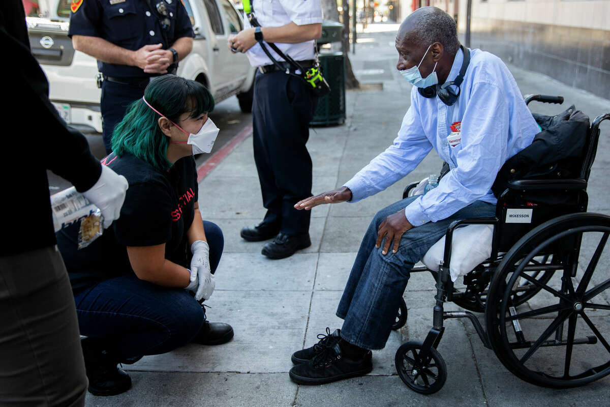 S.F. Street Crisis Response Team clinician Stephanie Chiri talks with Paul Lumpkin after he stopped the team to ask for resources near the corner of 16th and Mission streets.