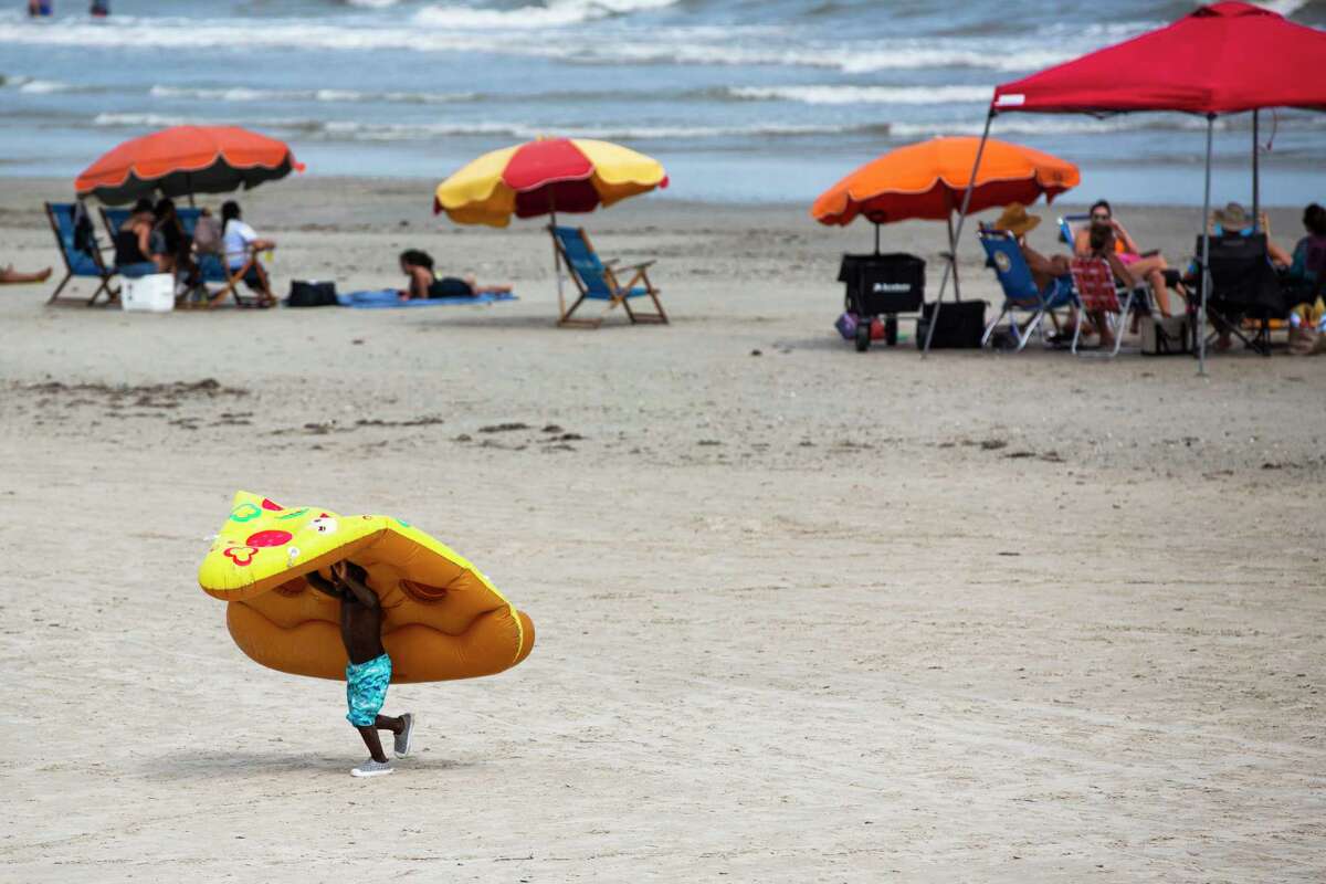 Zachary Hart, 5, drags a floater in the shape of a slice of pizza on Labor Day weekend on Saturday, Sept. 5, 2020, in Galveston. Hart and his family came to enjoy the beach in Galveston from Dallas.