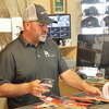 Cory Rambo, owner of Rambo Outdoors, completes a transaction for a customer order on Monday, Feb. 27, 2023, in Orange.