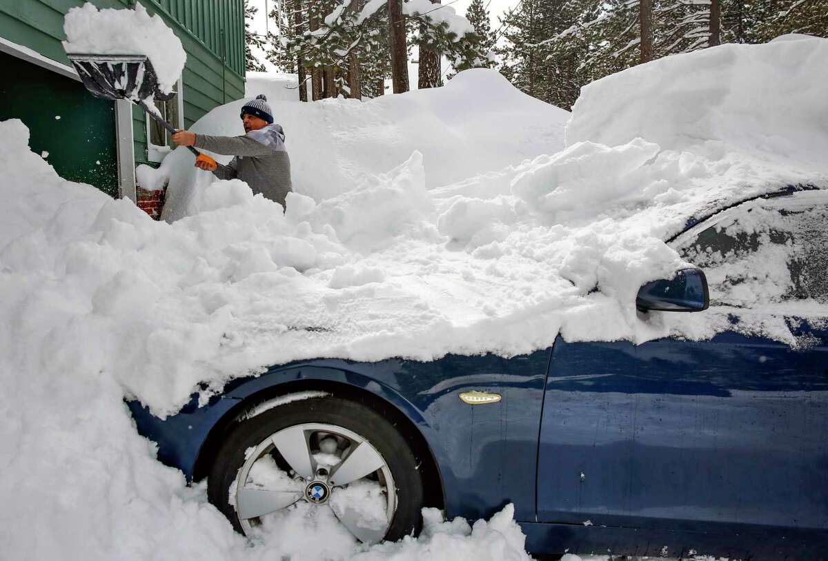 Carlos Gonzalez shovels snow off his car in front of his home in South Lake Tahoe, Calif., on Wednesday, March 1, 2023.