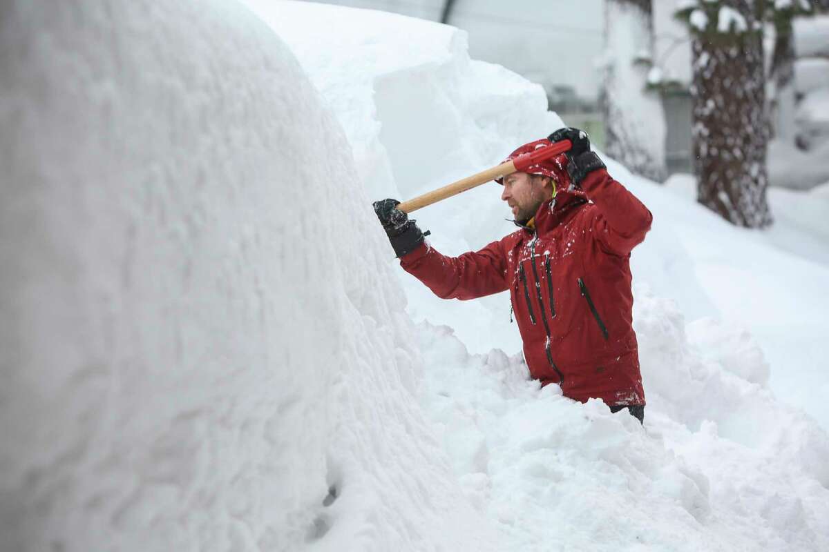 周三，一名男子在他在南太浩湖的出租物业前铲雪，因为该州的史诗般的积雪一直在增长。