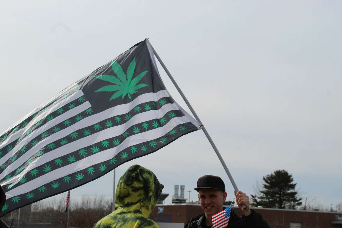 A small group of cannabis advocates protest outside of Hartford's Curaleaf location Friday. The state is reviewing ties between the cannabis production and retail giant and a Russian billionaire.
