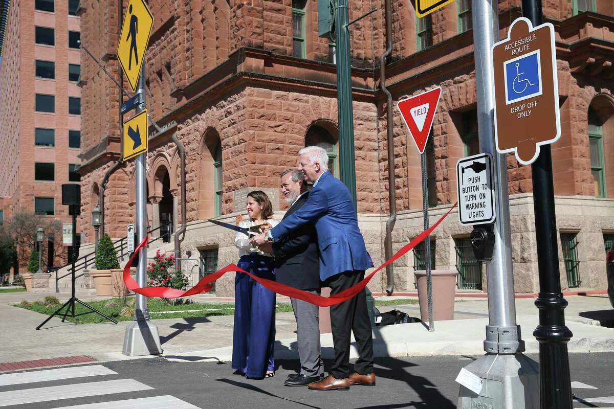 From left, Probate Court 2 Judge Veronica Vasquez, state District Judge Ron Rangel and Gordon Hartman cut the ribbon Friday on new zones for dropping off and picking up visitors to the Bexar County Courthouse.