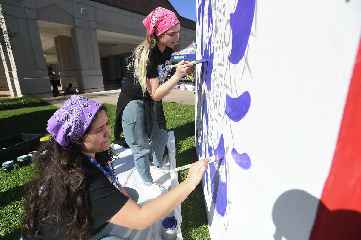 Eloisa Lopez (left) and Tiffany Ready team up on a panel of one of the cubes during the Mural Festival Sneak Peek at the Art Museum of Southeast Texas Friday. Photo made Friday, March 3, 2023 Kim Brent/Beaumont Enterprise
