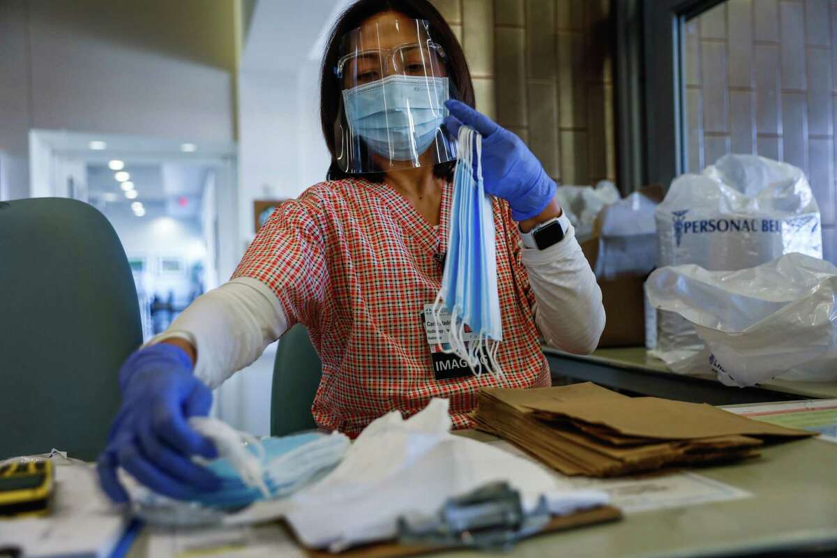 Radiology clerk Carin Madriaga organizes masks at Regional Medical Center of San Jose, an acute-care hospital, in December 2020. 
