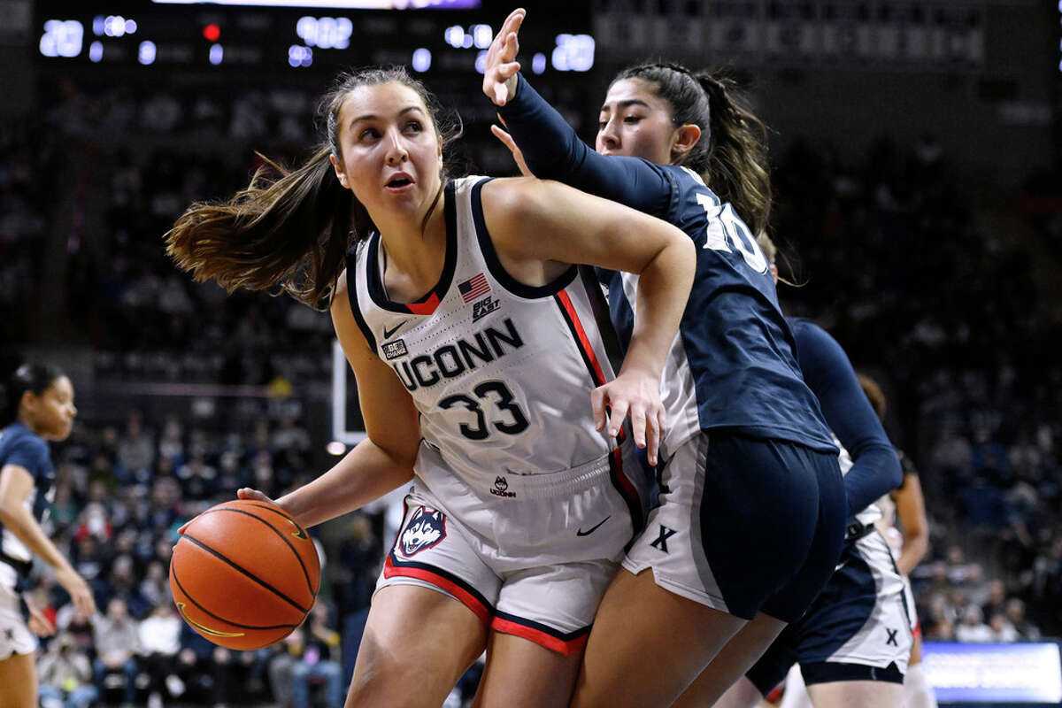 Connecticut's Caroline Ducharme (33) is defended by Xavier's Fernanda Ovalle (10) in the first half of an NCAA college basketball game, Monday, Feb. 27, 2023, in Storrs, Conn. (AP Photo/Jessica Hill)