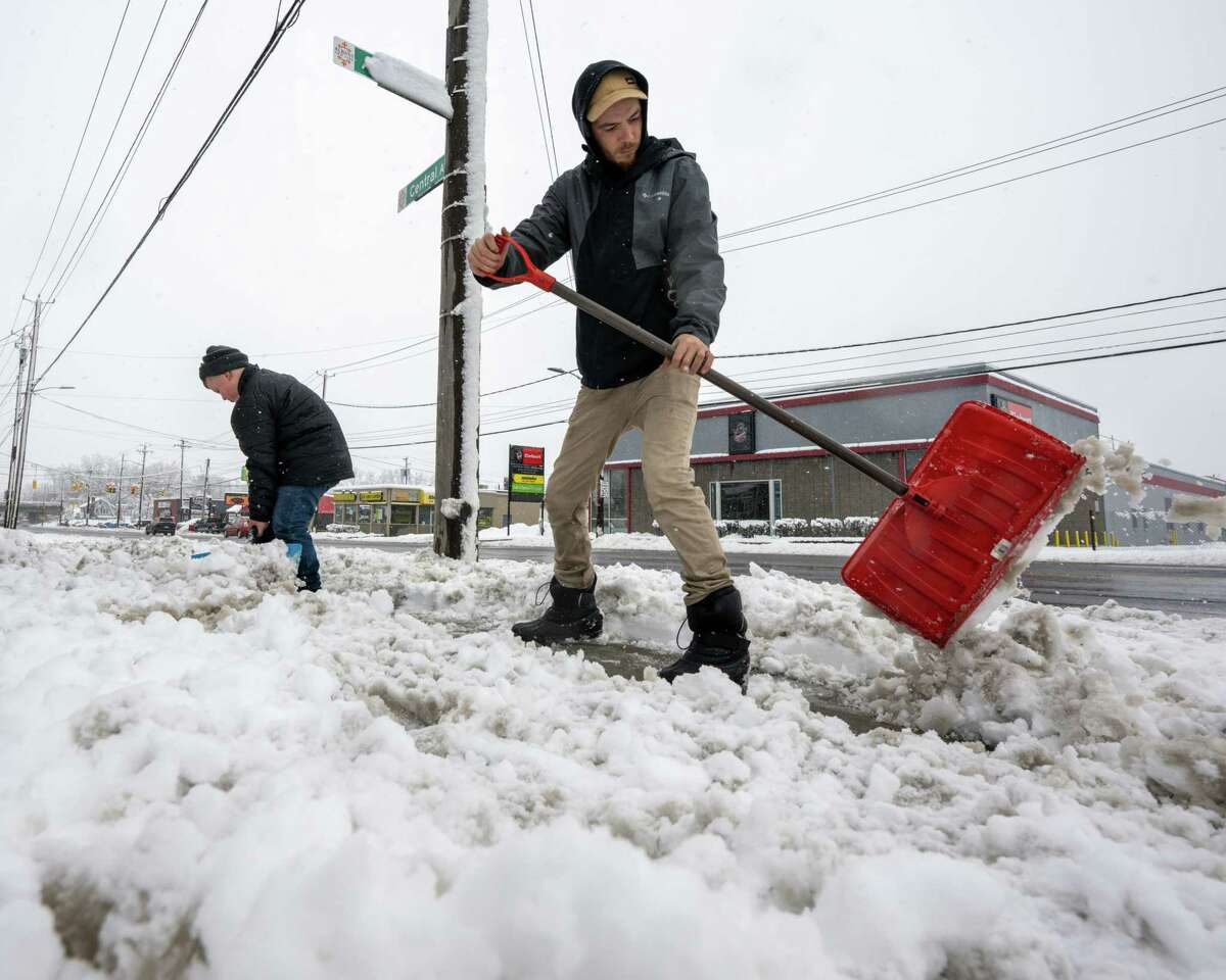 Jessie Asprion, left, and Sean Lawton, shovel snow on Saturday, March 4, 2023, along Central Avenue in Albany, NY.