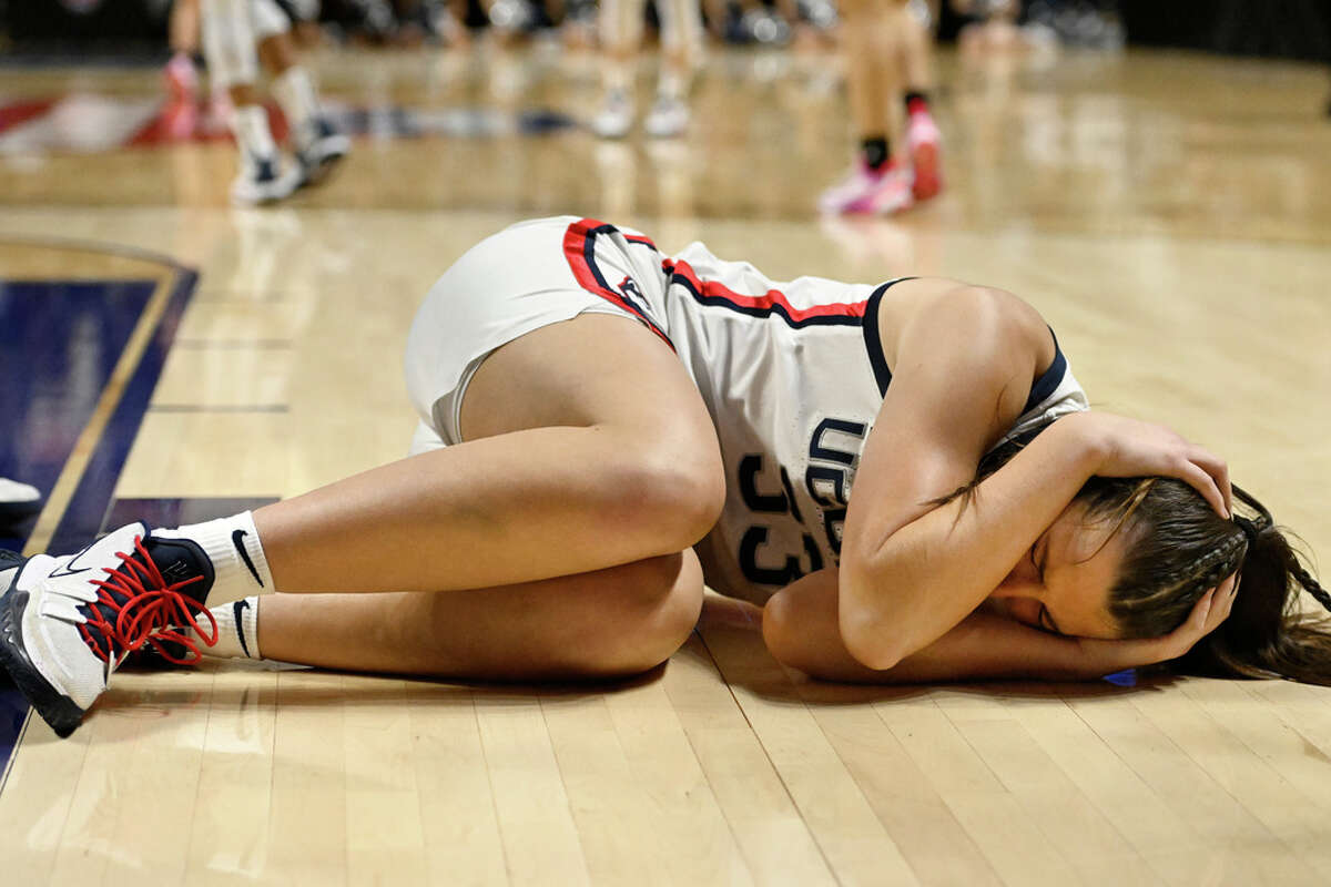 UConn's Caroline Ducharme (33) holds her head after a collision with teammate Aaliyah Edwards during the first half of an NCAA college basketball game against Georgetown in the quarterfinals of the Big East Conference tournament at Mohegan Sun Arena, Saturday, March 4, 2023, in Uncasville, Conn. (AP Photo/Jessica Hill)