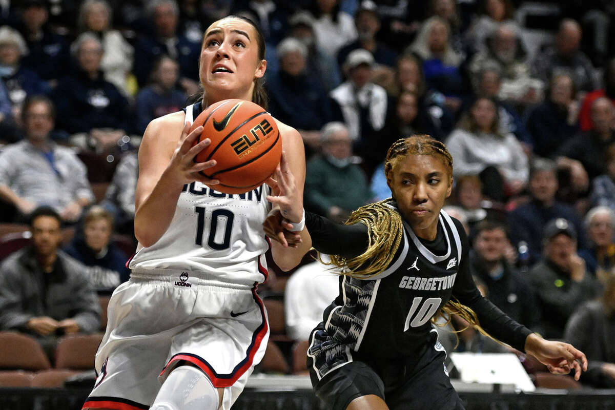 Georgetown's Kennedy Fauntleroy (10) fouls UConn's Nika Muhl (10) during the first half of an NCAA college basketball game in the quarterfinals of the Big East Conference tournament at Mohegan Sun Arena, Saturday, March 4, 2023, in Uncasville, Conn. (AP Photo/Jessica Hill)