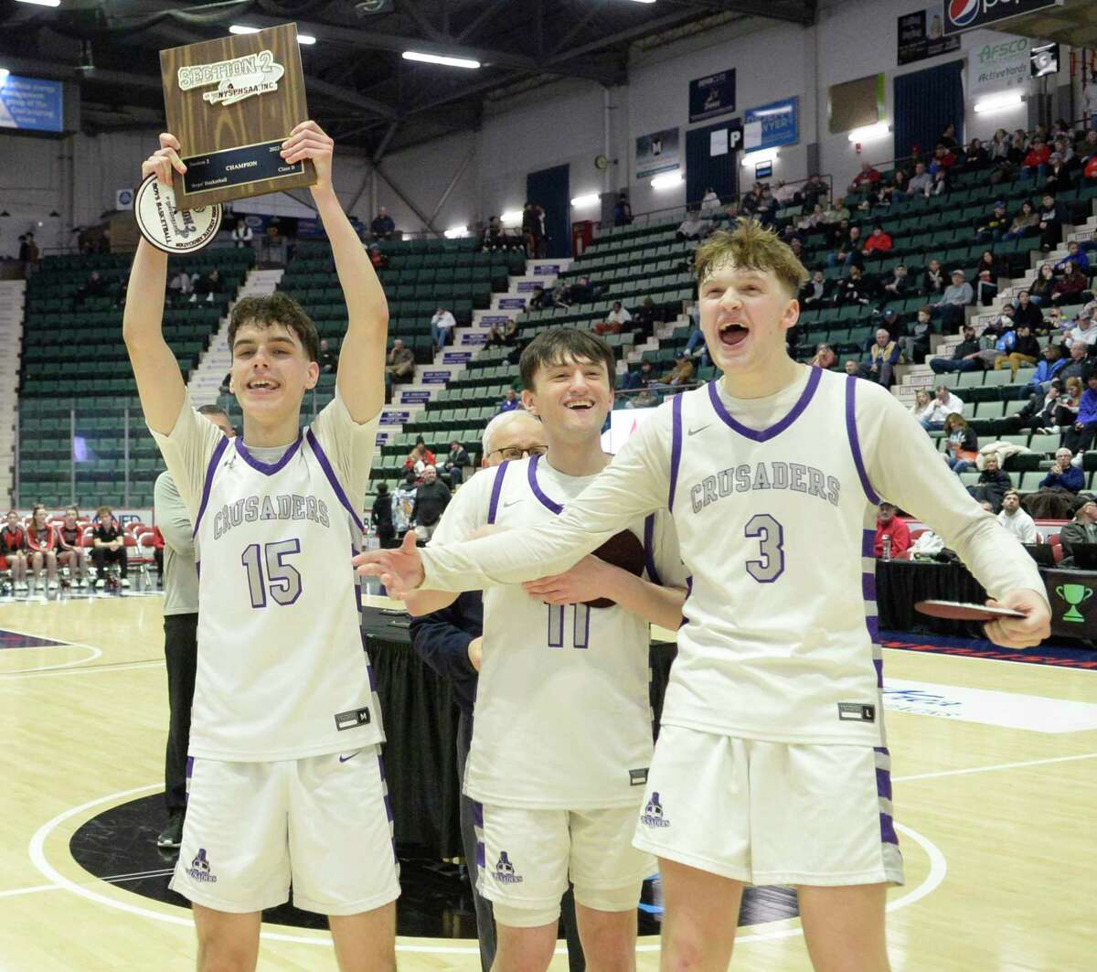 Catholic Central seniors Nick Riley (15), Nick Schrom (11), and Connor Gemmill present the Section II Champions plaque to their teammates following their win over Glens Falls in the Class B Championship at Cool Insuring Arena in Glens Falls, N.Y. on Saturday, Mar. 4, 2023. (Jenn March, Special to the Times Union)