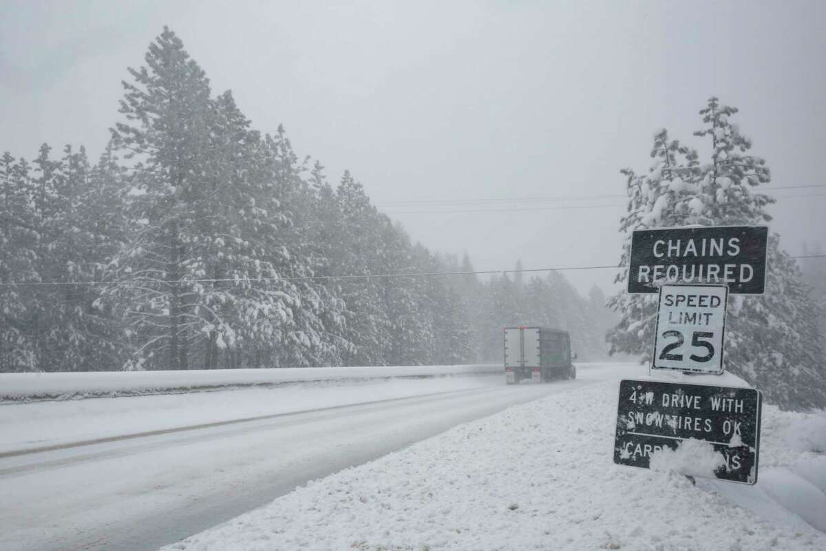 Chains required signs are shown during snowy road conditions along eastbound Highway 50 near Pollock Pines in late February. An early March storm has prompted more Sierra road closures.