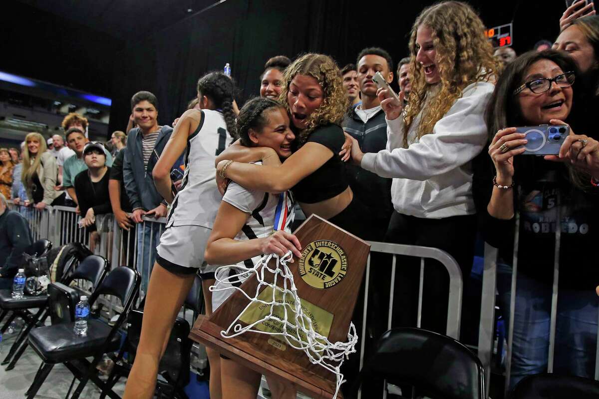 Clark Cougars’ Natalie Huff (1) and Clark Cougars’ Adrianna Roberson (12) celebrate with fans and family as Clark defeated DeSoto 42-37 in girls basketball Class 6A state championship game on Saturday, March 3, 2023 at the Alamodome.