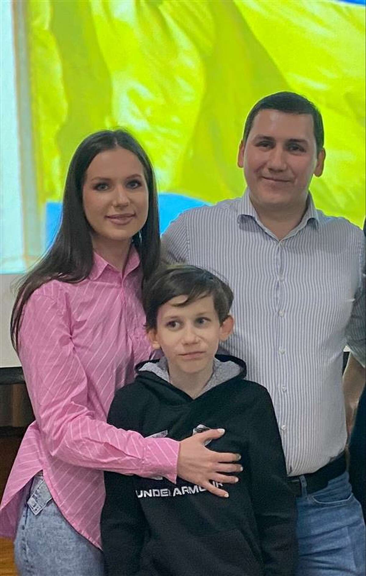 Khrystyna (left) and Sergii Pokanevych (right) pose with their son as Evelyn Winberg performs a ballet dance dedicated to all the girls in Ukraine who cannot dance during a Global Compassion, Inc. fundraiser dinner, March 4 at the Blessed Sacrament Parish.