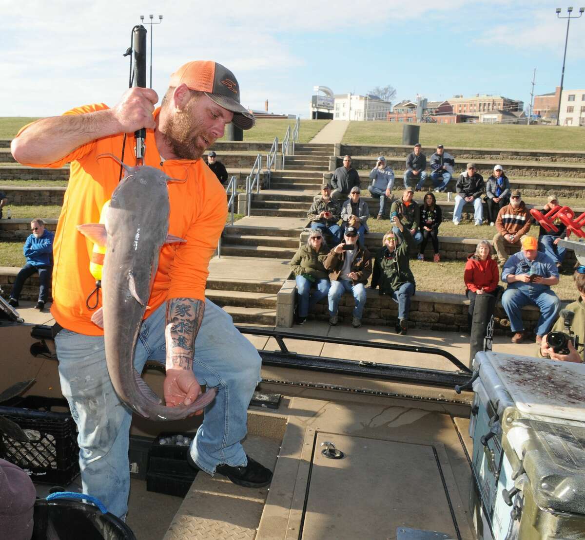 A competitor in Saturday's Twisted Cat Outdoors Fishing Series tournament in Alton shows off his catch to the crowd. High water, swift currents and Friday's rain were cited for the lower than expected catch.