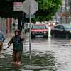 2022年12月31日星期六，人们试图疏通雨水排水沟，以帮助缓解加利福尼亚州旧金山教会区14街的洪水。