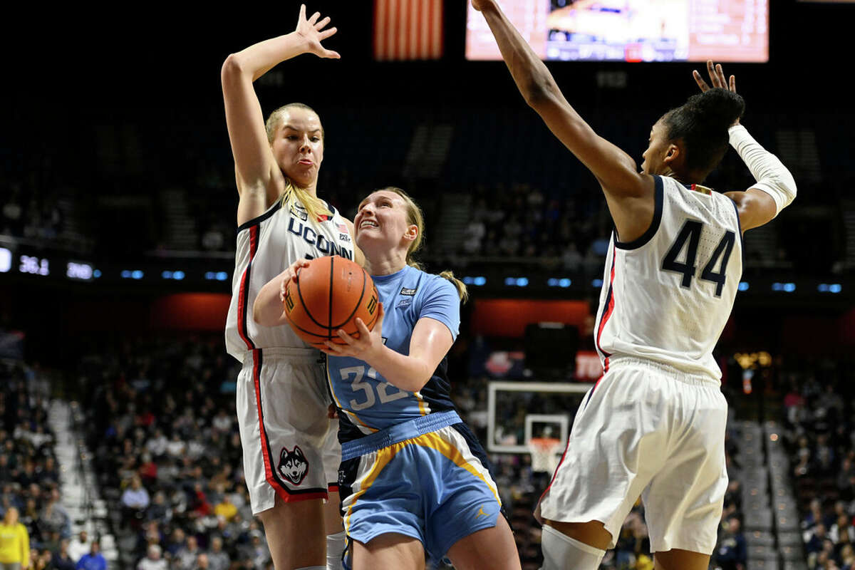 Marquette's Liza Karlen (32) splits between Connecticut's Dorka Juhasz and Aubrey Griffin (44) during the first half of an NCAA college basketball game in the semifinals of the Big East Conference tournament at Mohegan Sun Arena, Sunday, March 5, 2023, in Uncasville, Conn. (AP Photo/Jessica Hill)
