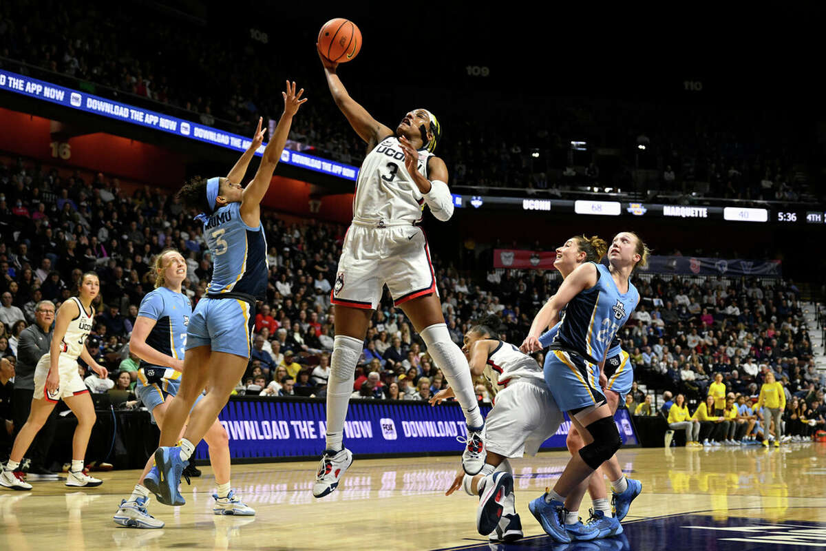 UConn's Aaliyah Edwards, center, pulls down an offensive rebound over Marquette's Rose Nkumu, front left, during the second half of an NCAA college basketball game in the semifinals of the Big East Conference tournament at Mohegan Sun Arena, Sunday, March 5, 2023, in Uncasville, Conn. (AP Photo/Jessica Hill)