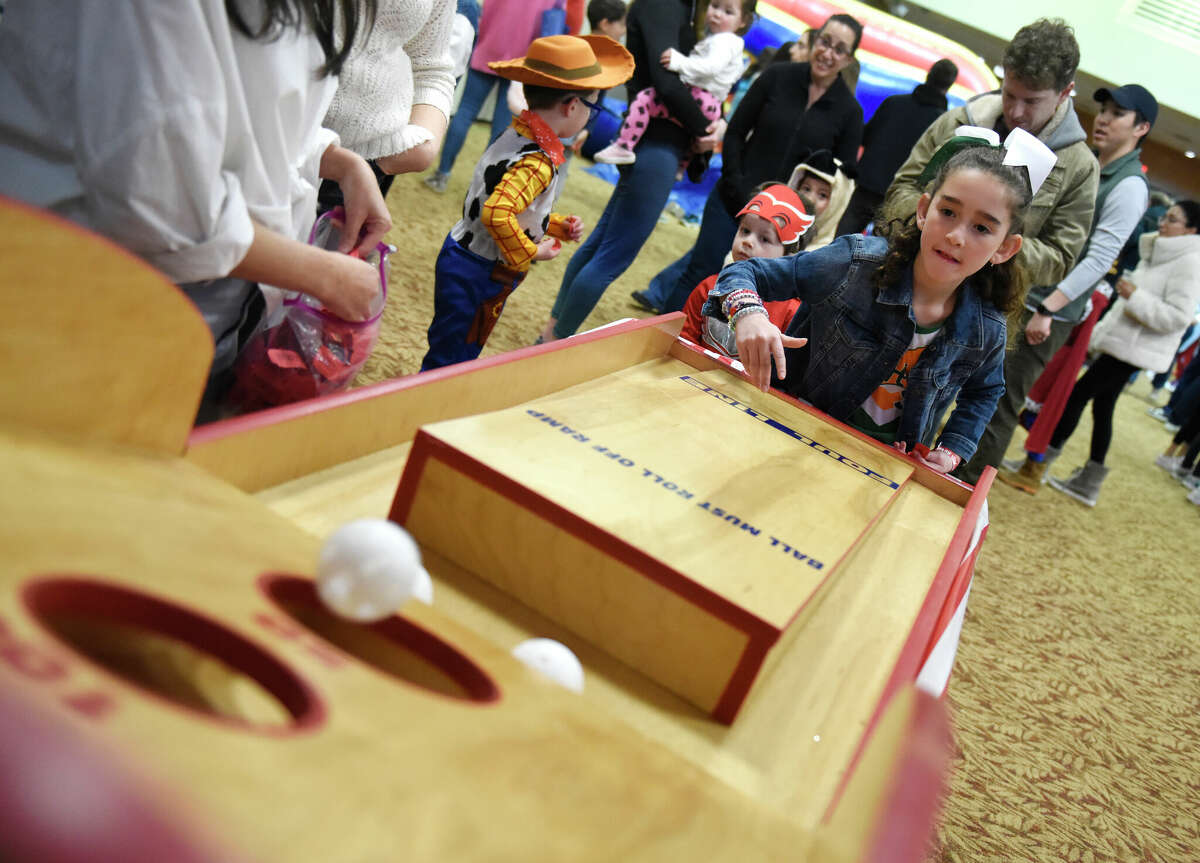 Greenwich's Sienna Smith, 9, plays skee ball during the Purim Carnival at Temple Sholom in Greenwich, Conn. Sunday, March 5, 2023. Kids dressed in costumes and enjoyed festivities including a bounce house, face painting, sand art, arcade-style games, and delicious traditional food. Purim is a celebration commemorating the salvation of the Jewish people from Haman's diabolical plot in the ancient Persian Empire.