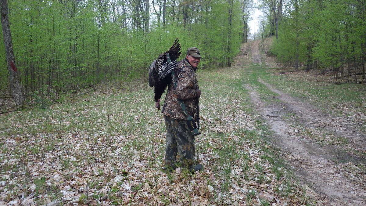 Tom Lounsbury is shown with his 2015 spring turkey that was called into range by his new friends, John Jones and Gary Morgan, both of whom are registered Michigan hunting guides.