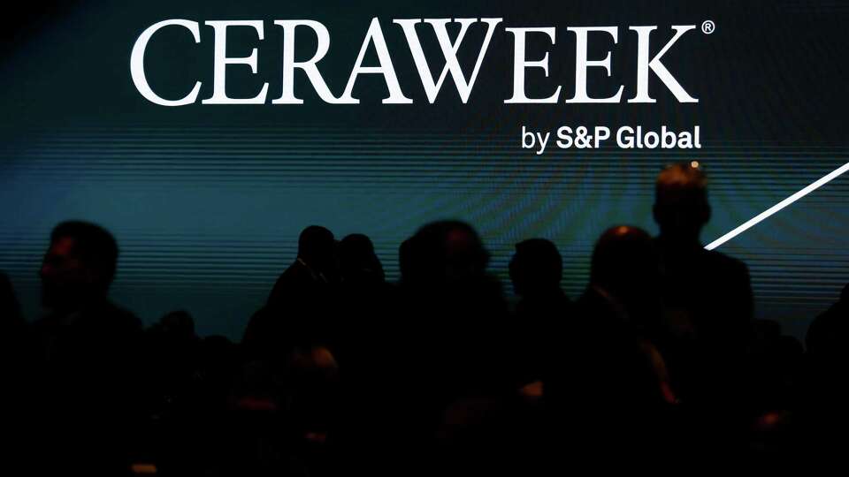 Conference attendees are silhouetted against a big screen projector in the Plenary Americas after an executive session during CERAweek 2023, held at the Hilton Americas and George R. Brown Convention center Monday, March 6, 2023 in Houston.