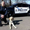 Police officer James Cox poses with K9 officer Winston at the Milford Police Academy, in Milford, Conn. March 6, 2023.