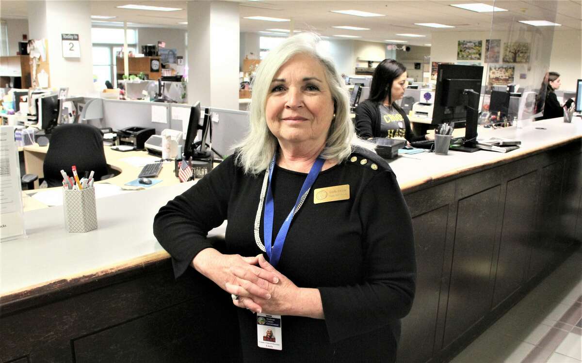 Newly-elected Madison County Clerk/Recorder Linda Andreas stands at the counter to the Clerk's Office at the Madison County Administration Building as workers help customers. The office is gearing up for the April 4 Consolidated Election, which will be Andreas' first as clerk.