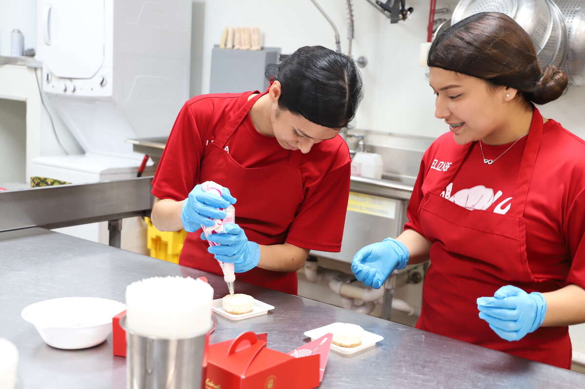 Leyla Alvarez and Elizabeth Bedarte of Martin High School are putting the culinary skills to learning to prepare fruit baskets and other treats at Edible Arrangements.