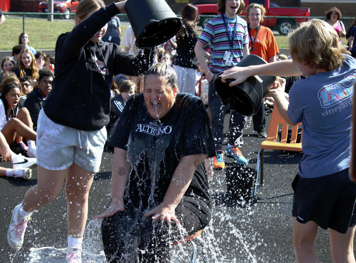 Carla Kinsey, seventh-grade language arts teacher, goes 'under the buckets' Monday in the Polar Plunge at Lincoln Middle School in Edwardsville.