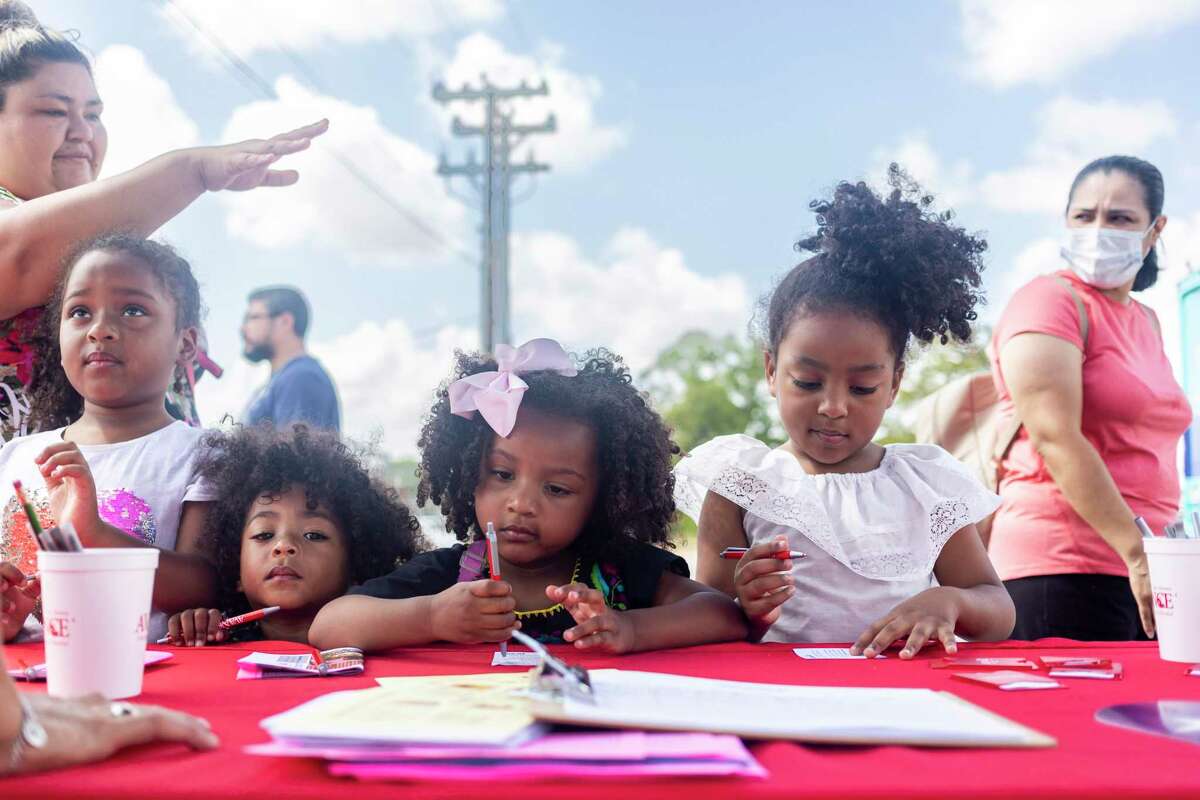 Sisters Raheema, 6, Thaliah, 2, Aiya, 3, and Nailah Chouwat, 5, try out pens at a rescource table during a back to school event at the Harlandale Alternative Center last August. Fewer school-age children in the district have contributed to enrollment declines and a proposal to close four of its schools.