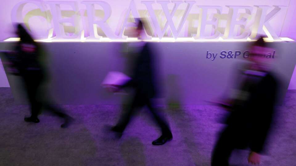 Attendees pass by a CERAWeek display in the Agora-Innovation space during CERAweek 2023, held at the Hilton Americas and George R. Brown Convention center Monday, March 6, 2023 in Houston.