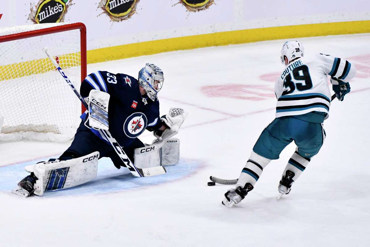 The Sharks’ Logan Couture nets the game-winning goal past Winnipeg Jets goaltender David Rittich.