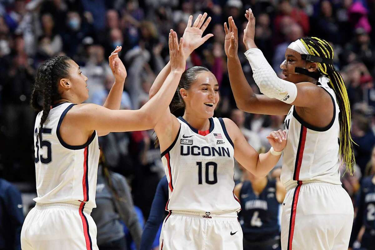 UConn's Azzi Fudd (35), Nika Muhl (10) and Aaliyah Edwards celebrate after their win over Villanova on Monday in the Big East final.